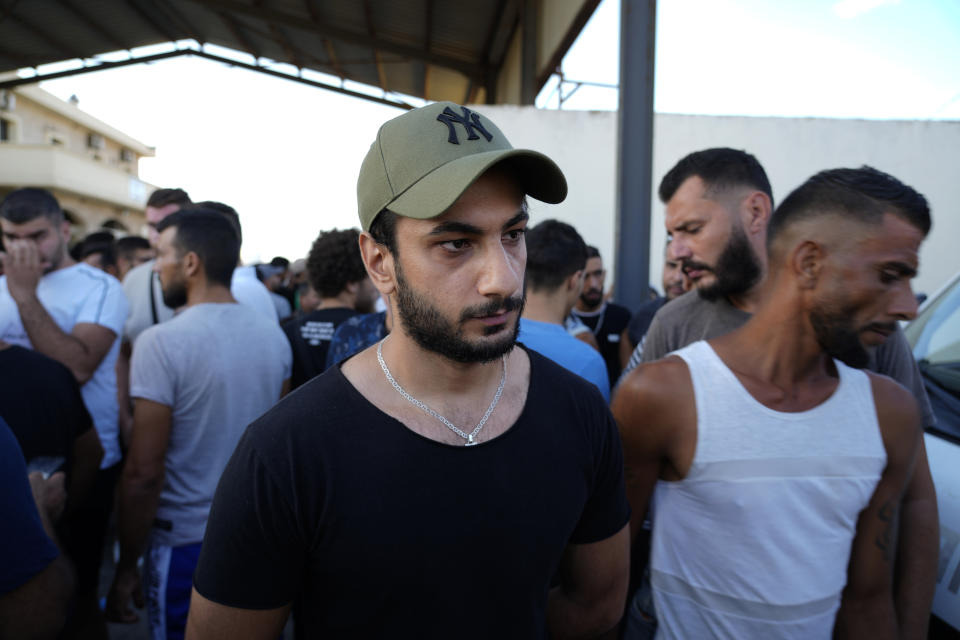 A Palestinian man Youssef al-Sayyed, center, who informed that his 15-year old brother Rawad found dead at a hospital in the Syrian city of Tartus, who was on a boat carrying migrants from Lebanon that sank in Syrian waters, as he waits to receive his dead body, at Arida border crossing point between Lebanon and Syria, north Lebanon, Sept. 23, 2022. Syria's health minister says several people have been killed from a boat that sank migrants from Lebanon off Syria's coast. The incident is the deadliest since a surging number of Lebanese, Syrians, and Palestinians have tried to flee crisis-hit Lebanon by sea to Europe. (AP Photo/Bilal Hussein)