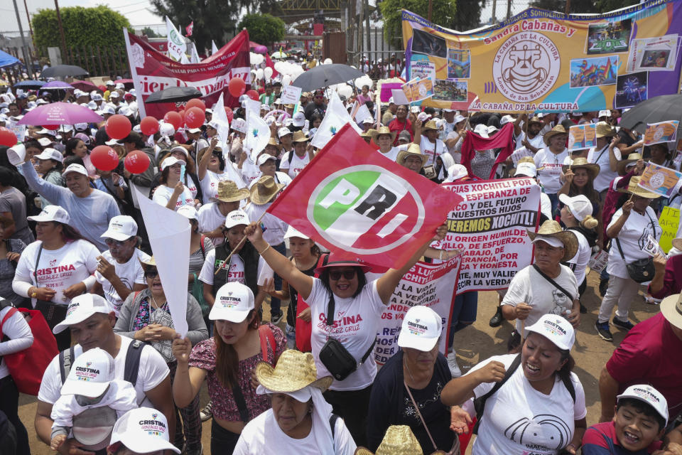 Supporters of presidential candidate Xochitl Galvez, one holding a PRI political party flag, attend her campaign rally in Los Reyes la Paz just outside of Mexico City, Wednesday, May 29, 2024. (AP Photo/Fernando Llano)