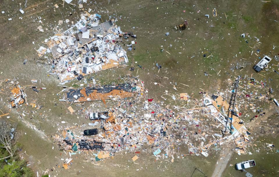 Debris from a mobile home where two people were killed stretches along Gilberts Mill Road outside of Alford on Thursday.