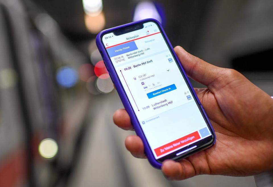 Ein junger Mann nutzt am Hauptbahnhof die Bahn-App DB Navigator. Ab sofort lassen sich darüber auch Entschädigungen für Verspätungen anfordern.