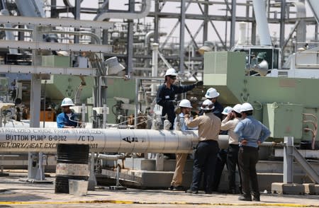 Workers are seen at the damaged site of Saudi Aramco oil facility in Khurais