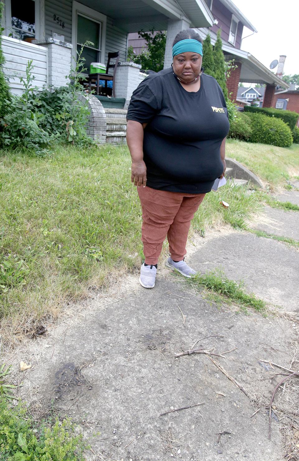 Vinesa Glenn looks at the area of sidewalk where her dog Brownie was shot and killed by a police officer last week. 