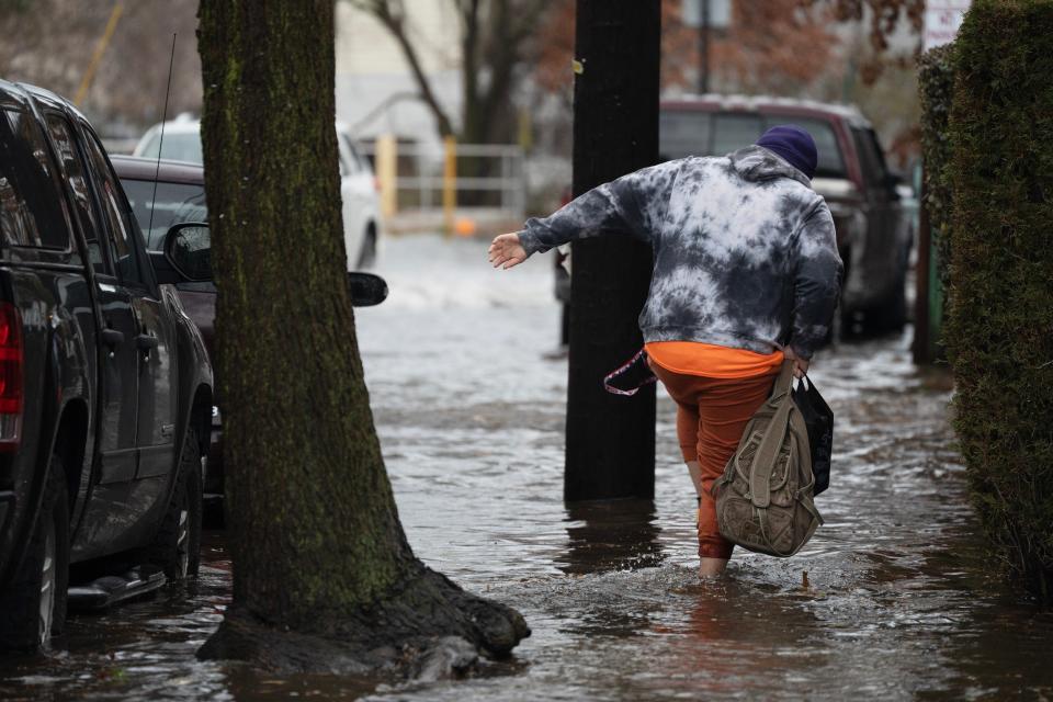 A man walks through high water along Bergen Turnpike in Ridgefield Park, N.J. on Friday Dec. 23, 2022. 