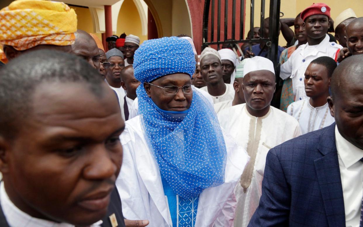 Leading opposition presidential candidate Atiku Abubakar, centre, leaves after attending traditional Friday prayers at the central mosque in Yola Nigeria - AP