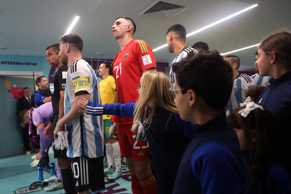 DOHA, QATAR - DECEMBER 03: Escort children interact with Lionel Messi of Argentina prior to the FIFA World Cup Qatar 2022 Round of 16 match between Argentina and Australia at Ahmad Bin Ali Stadium on December 03, 2022 in Doha, Qatar. (Photo by Maja Hitij - FIFA/FIFA via Getty Images)