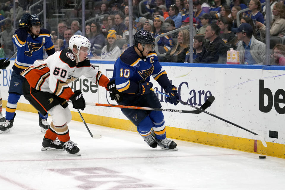 St. Louis Blues' Brayden Schenn (10) and Anaheim Ducks' Jackson LaCombe (60) chase after a loose puck along the boards during the second period of an NHL hockey game Sunday, March 17, 2024, in St. Louis. (AP Photo/Jeff Roberson)