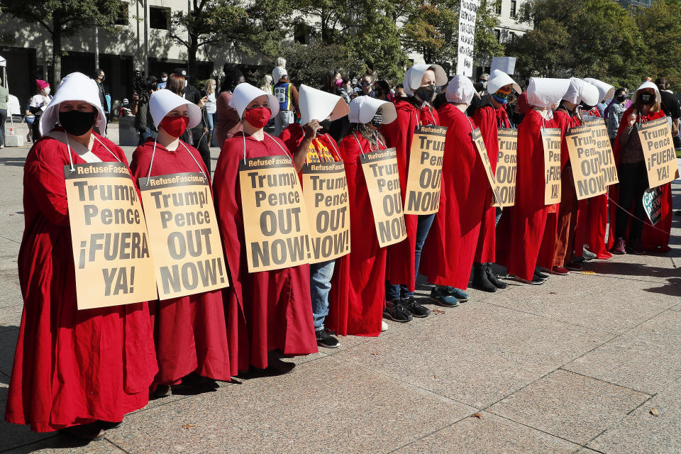 Women dressed as handmaidens protest against Donald Trump's presidency on Saturday. (Photo: Paul Morigi via Getty Images)