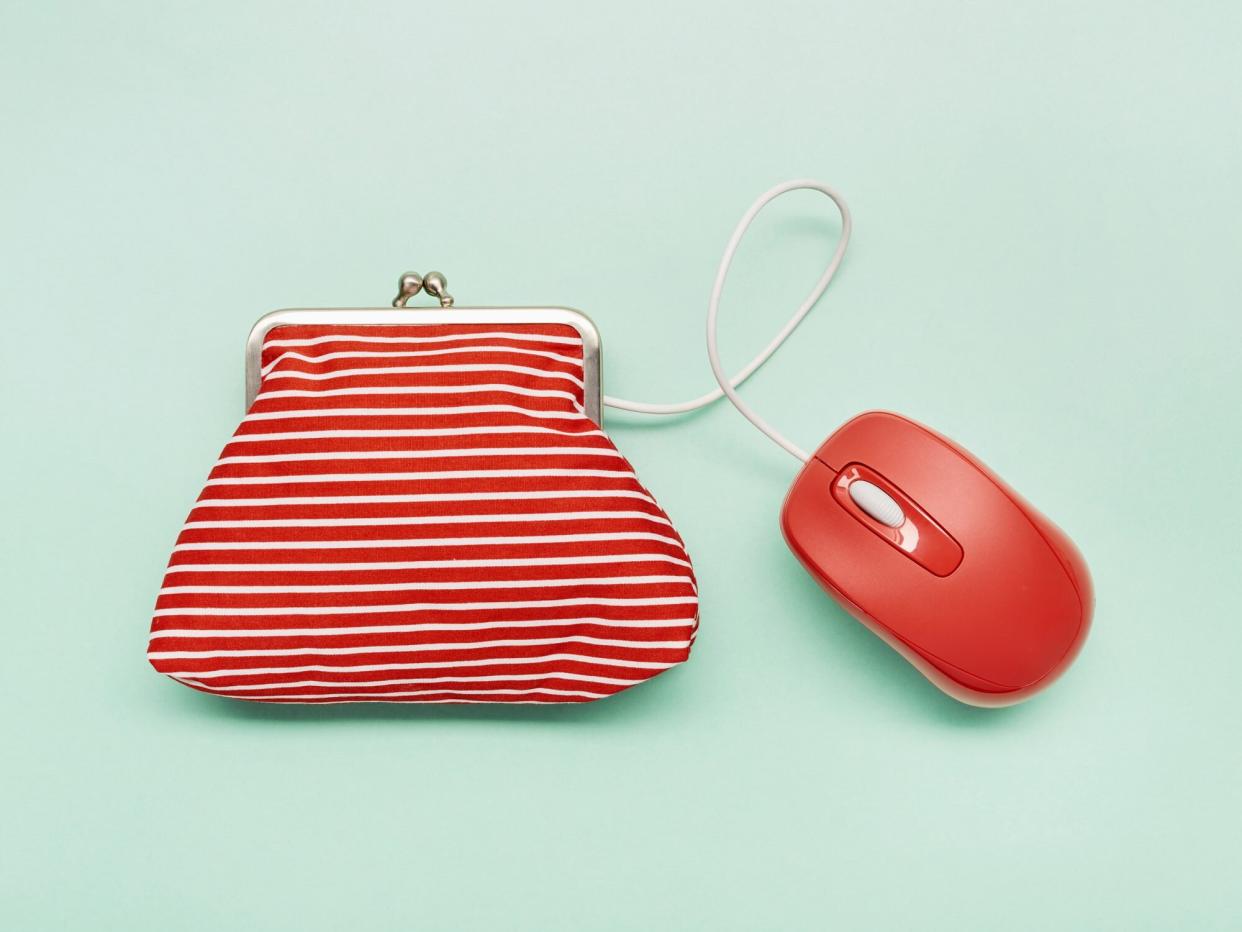 Still life of a wallet and red computer mouse on green background