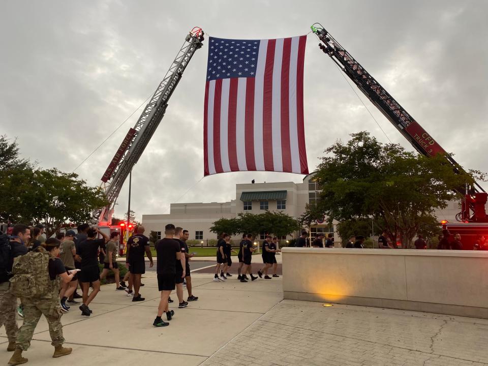 Participants in the Army 7th Special Forces Group (Airborne) 9/11 Memorial Run passed under an American flag as they took off Friday.