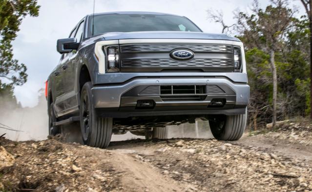 The 2022 Ford F-150 Lightning Lariat driving on a dirt road.