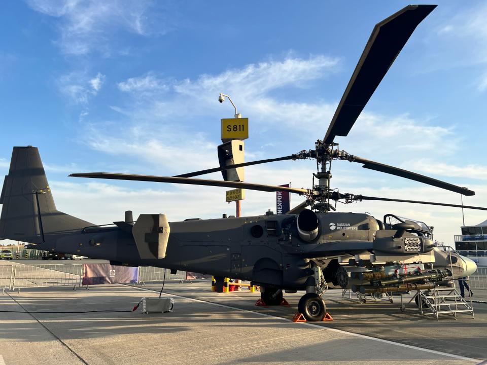 A black Ka-52 attack helicopter is viewed from the side at the Dubai Airshow