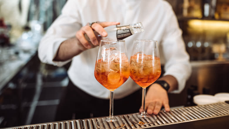 bartender mixing orange cocktails