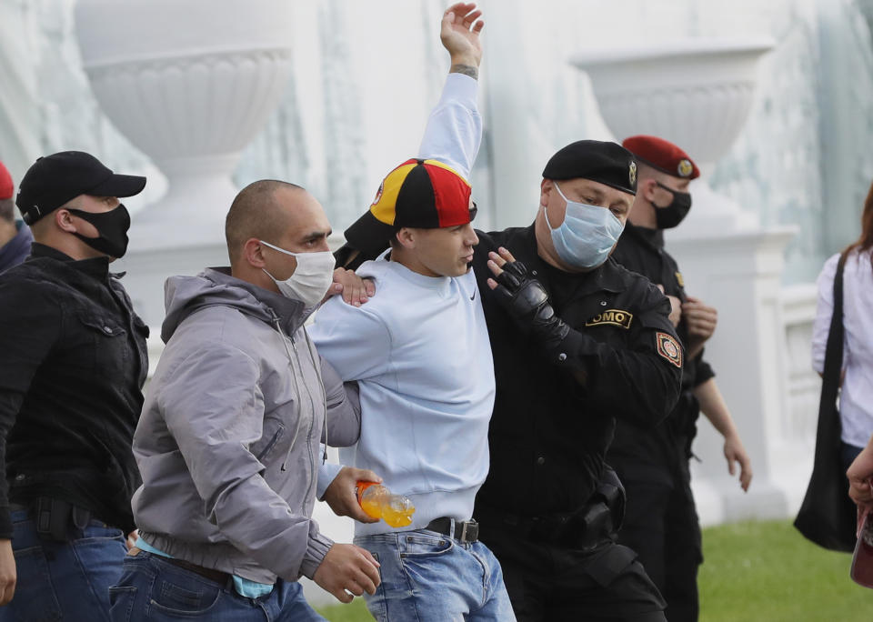 Police officers detain a protester during a rally against the removal of opposition candidates from the presidential elections in Minsk, Belarus, Tuesday July 14, 2020. Election authorities in Belarus on Tuesday barred two main rivals of authoritarian leader Alexander Lukashenko from running in this summer's presidential election. (AP Photo/Sergei Grits)