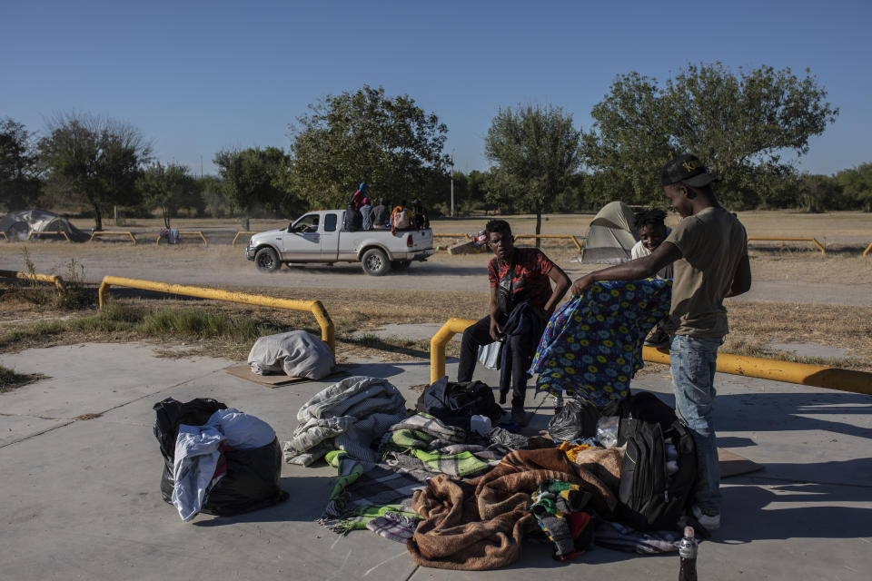 A group of migrants are driven away on the back of a truck at an encampment after agreeing to be transferred to a shelter, in Ciudad Acuna, Mexico, Friday, Sept. 24, 2021, across the Rio Grande from Del Rio, Texas. No migrants remained Friday at the Texas border encampment in Del Rio where almost 15,000 people — most of them Haitians — had converged just days earlier seeking asylum, local and federal officials said. (AP Photo/Felix Marquez)