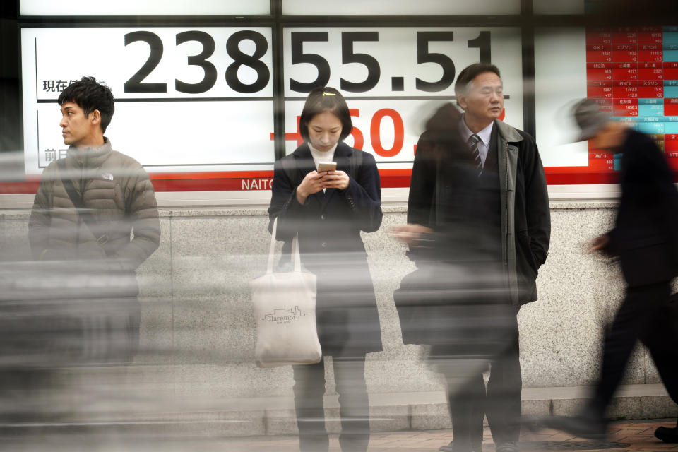 People stand in front of an electronic stock board showing Japan's Nikkei 225 index at a securities firm in Tokyo Friday, Jan. 24, 2020. Shares are mostly higher in quiet trading as China closes down for its week-long Lunar New Year festival. (AP Photo/Eugene Hoshiko)