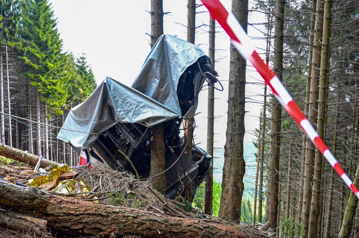 A view shows the cabin's wreckage covered with a tarpaulin on May 26, 2021 on the slopes of the Mottarone peak above Stresa, Piedmont, three days after a cable car crash that killed 14.