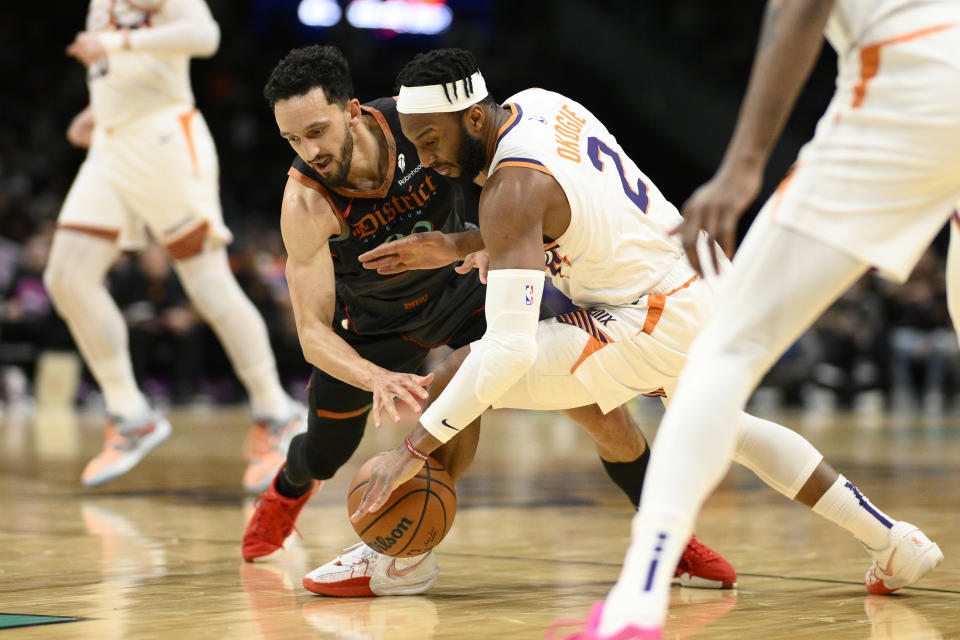 Washington Wizards guard Landry Shamet, left, and Phoenix Suns forward Josh Okogie (2) battle for the ball during the first half of an NBA basketball game, Sunday, Feb. 4, 2024, in Washington. (AP Photo/Nick Wass)