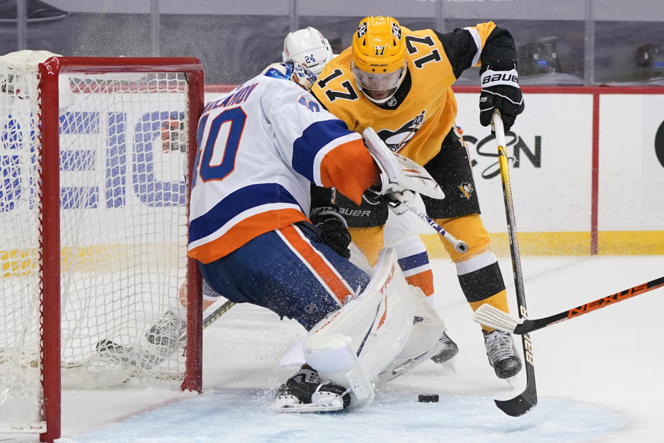 Pittsburgh Penguins' Bryan Rust, right, can't get a shot past New York Islanders goaltender Semyon Varlamov, left, as they collide during the second period in Game 2 of an NHL hockey Stanley Cup first-round playoff series in Pittsburgh, Tuesday, May 18, 2021. (AP Photo/Gene J. Puskar)