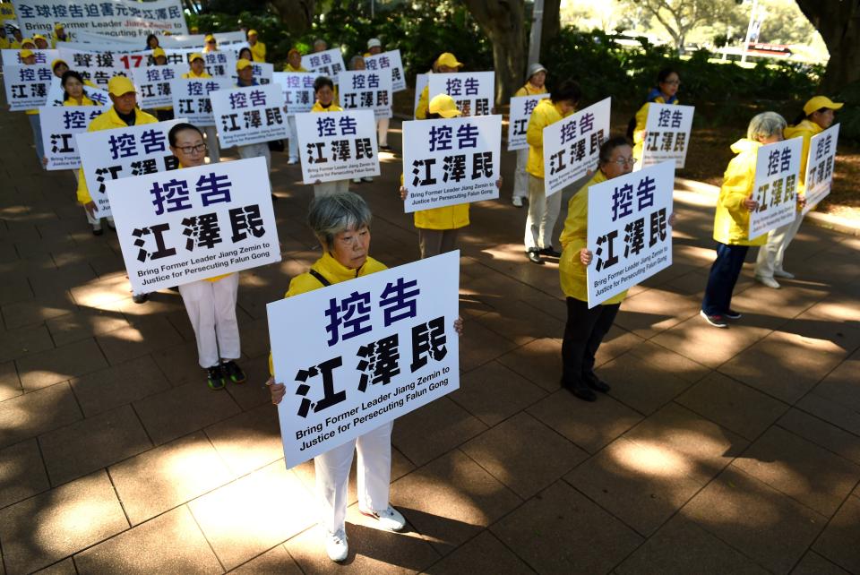 Falungong practitioners march to show their support for the global lawsuit action against Chinas former President Jiang Zemin (1993-2003), who is being sued for crimes including genocide and torture, in Sydney on September 4, 2015.  Over 160,000 Falun Gong practitioners in China and all over the world, including Australia, have filed criminal complaints with the Chinese Supreme Procuratorate against Jiang Zemin. The group was banned in China in 1999, when 10,000 of its followers converged peacefully near the Communist government headquarters in Beijing, in what was considered the largest demonstration since Tiananmen a decade earlier. AFP PHOTO/William WEST        (Photo credit should read WILLIAM WEST/AFP via Getty Images)