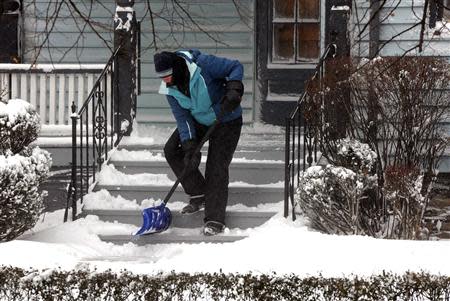An Elmwood Village resident clears snow on Anderson Place in Buffalo, New York January 7, 2014. REUTERS/Don Heupel