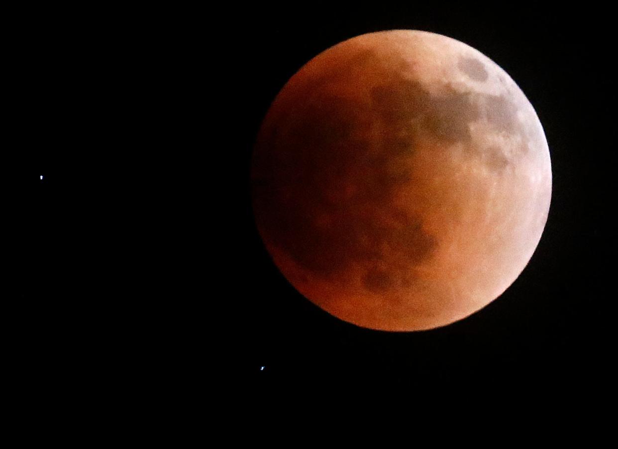 The super flower blood moon lunar eclipse is seen Sunday night in the sky over Mifflin Township. With the moon totally eclipsed by Earth's shadow, two stars that would normally be washed out by the full moon are visible. TOM E. PUSKAR/TIMES-GAZETTE.COM