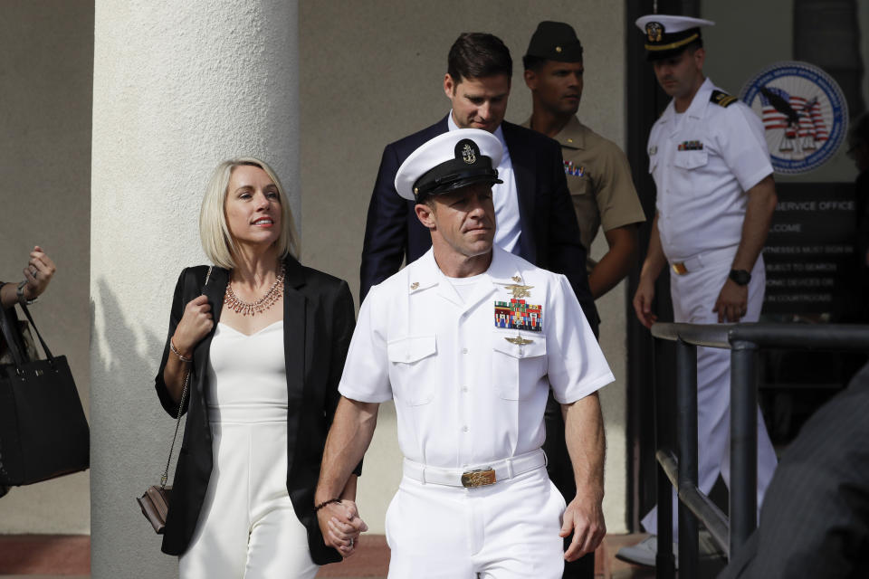 File - In this July 2, 2019, file photo, Navy Special Operations Chief Edward Gallagher, center, walks with his wife, Andrea Gallagher, as they leave a military court on Naval Base San Diego in San Diego. The acting Navy secretary has canceled a peer-review process for three Navy SEALs who supervised a fourth SEAL convicted of posing with a dead teenage prisoner in Iraq. Acting Navy Secretary Thomas Modly said Wednesday, Nov. 27, 2019, the case was becoming a distraction. The decision comes after President Donald Trump intervened in the case of Chief Petty Officer Gallagher. (AP Photo/Gregory Bull, File)