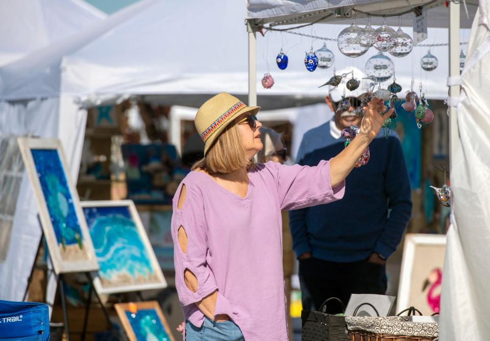 Art lovers check out the art during the 27th annual Gulf Breeze Celebrates the Arts Festival in 2022. Now in its 27th year, the festival is March 25-26 at Gulf Breeze High School.