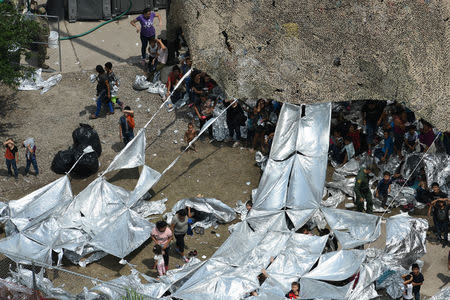 Migrants are seen outside the U.S. Border Patrol McAllen Station in a makeshift encampment in McAllen, Texas, U.S., May 15, 2019. REUTERS/Loren Elliott