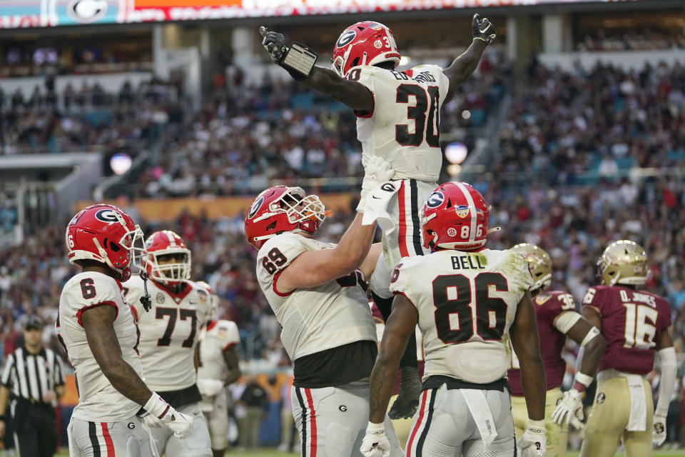 Georgia running back Daijun Edwards (30) is lifted into the air by offensive lineman Chris Brown (68) after scoring touchdown during the first half of Orange Bowl NCAA college football game, Saturday, Dec. 30, 2023, in Miami Gardens, Fla. (AP Photo/Lynne Sladky)
