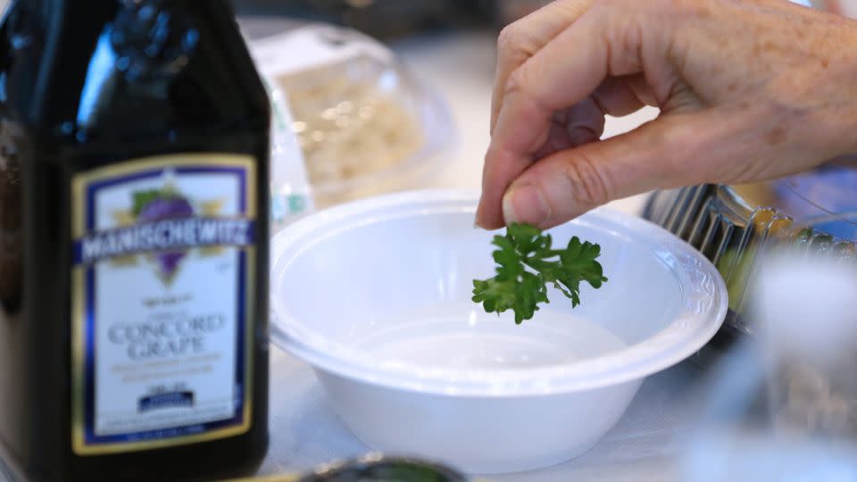 Parsley, which represents spring, is dipped into salty walter that represents tears. - Angela Rowlings/Boston Herald/Getty Images