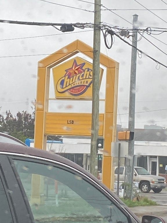 sign reading LSD below a Church's Chicken logo