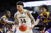 Cincinnati's Jarron Cumberland (34) drives against East Carolina's Brandon Suggs (4) during the second half of an NCAA college basketball game, Sunday, Jan. 19, 2020, in Cincinnati. (AP Photo/John Minchillo)