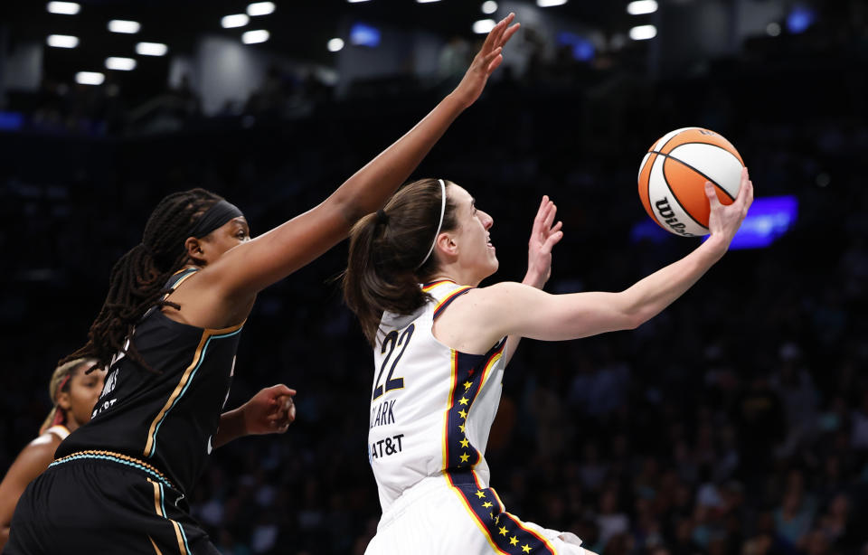 Indiana Fever guard Caitlin Clark (22) drives to the basket past New York Liberty forward Jonquel Jones (35) during the first half of a WNBA basketball game, Saturday, May 18, 2024, in New York. (AP Photo/Noah K. Murray)