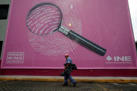 A man walks past a National Electoral Institute (INE) billboard ahead of the upcoming July 1 presidential election, in Mexico City, Mexico, June 30, 2018. REUTERS/Daniel Becerril