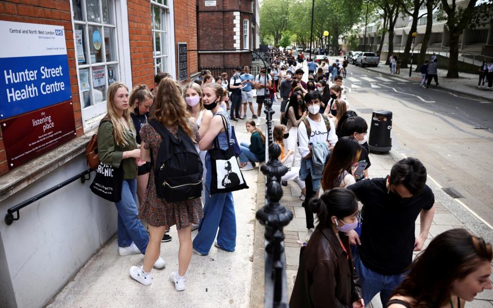 People queue outside a vaccination centre for young people and students at the Hunter Street Health Centre - HENRY NICHOLLS/REUTERS