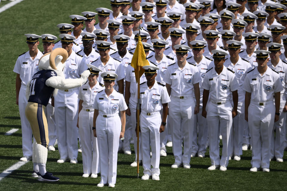 Navy mascot, Bill the goat, adjusts the hat of a midshipman during the brigade march-on before an NCAA college football game between Navy and Delaware, Saturday, Sept. 3, 2022, in Annapolis, Md. (AP Photo/Nick Wass)