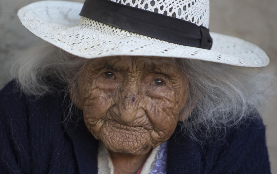 Julia Flores Colque eyes the camera while sitting outside her home in Sacaba, Bolivia, Thursday, Aug. 23, 2018. Her national identity card says Flores Colque was born on Oct. 26, 1900 in a mining camp in the Bolivian mountains. At 117 and just over 10 months, she would be the oldest woman in the Andean nation and perhaps the oldest living person in the world. (AP Photo/Juan Karita)