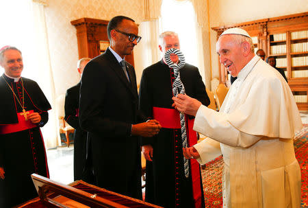 Pope Francis talks with Rwanda's President Paul Kagame as he receives a gift during a private meeting at the Vatican March 20, 2017. REUTERS/Tony Gentile