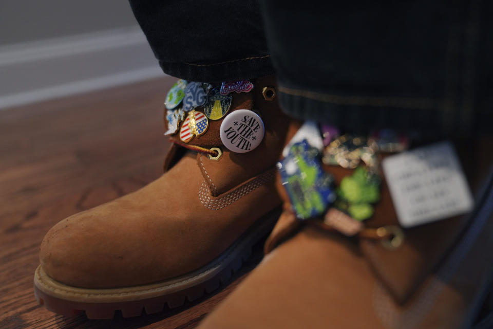 Jonathan Diggs wears a collection of pins on his boots on Sunday, Feb. 18, 2024, at his family home in Nashville, Tenn. Diggs is one of the founders of The Cove, an 18-and-up, pop-up Christian nightclub. (AP Photo/Jessie Wardarski)