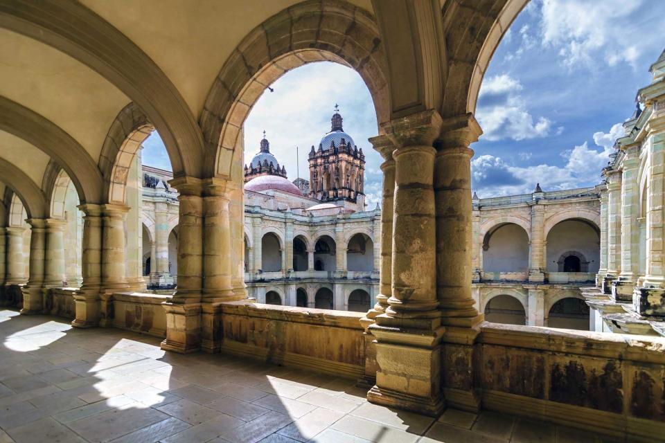 View of a Catholic church in Oaxaca, Mexico, looking onto a courtyard from an arched terrace