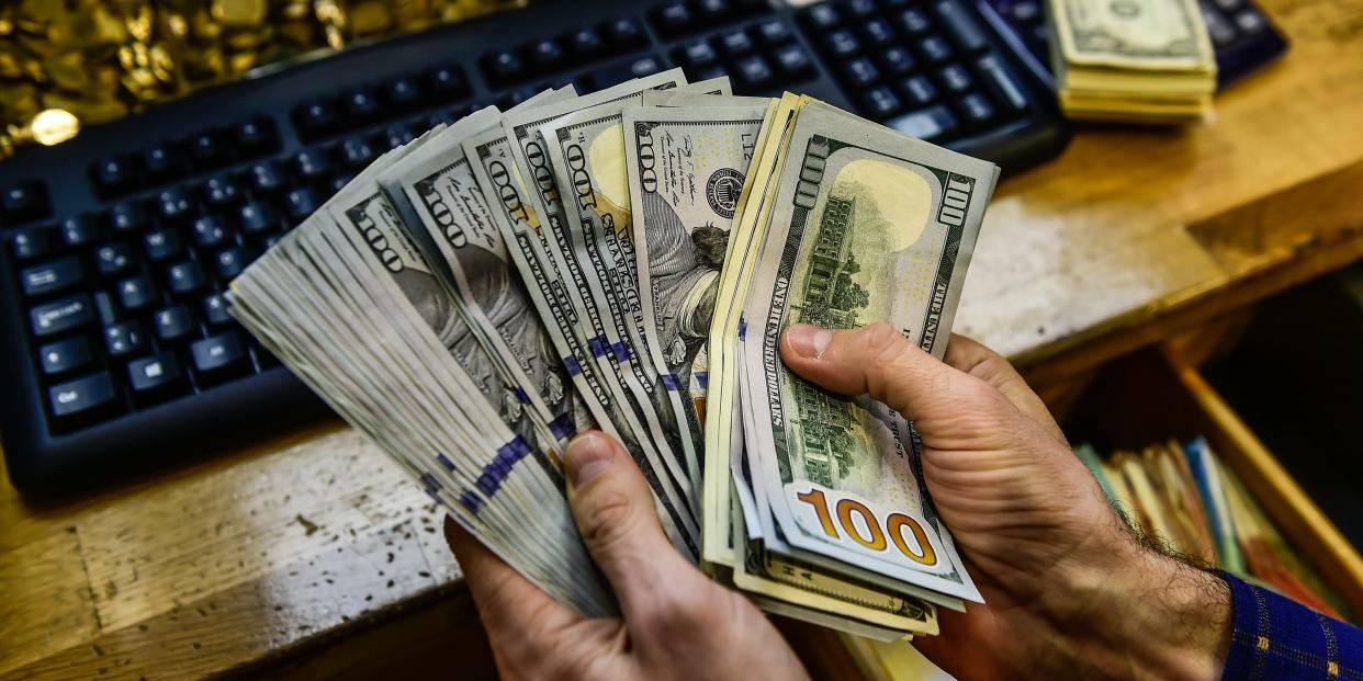 A man holds up dollar bills in a money exchange office in Istanbul, Turkey.