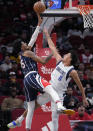 Houston Rockets center Christian Wood, left, shoots as Dallas Mavericks guard Josh Green defends during the first half of an NBA basketball game Friday, Jan. 7, 2022, in Houston. (AP Photo/Eric Christian Smith)