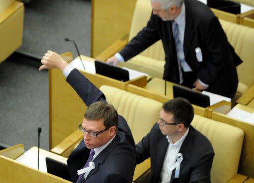 Wearing white ribbons, a symbol of the Russian opposition, "Just Russia" party members vote against a new bill that would steeply increase fines for illegal protest activity, in the State Duma lower house of parliament, in Moscow, May 22, 2012