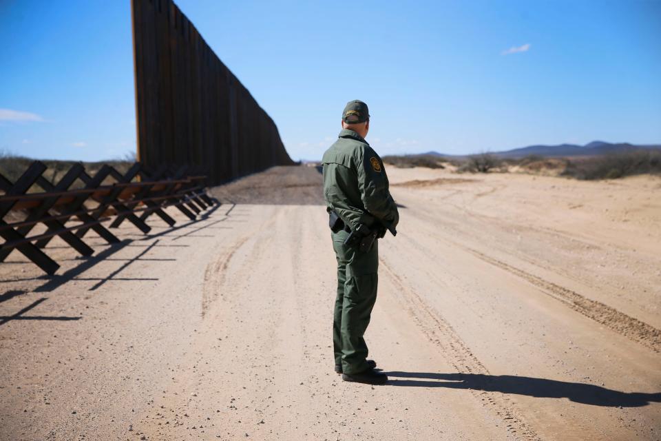Border Patrol Agent Joe Romero monitors a dirt road near the government-funded border fence under construction Feb. 13 in El Paso, Texas.