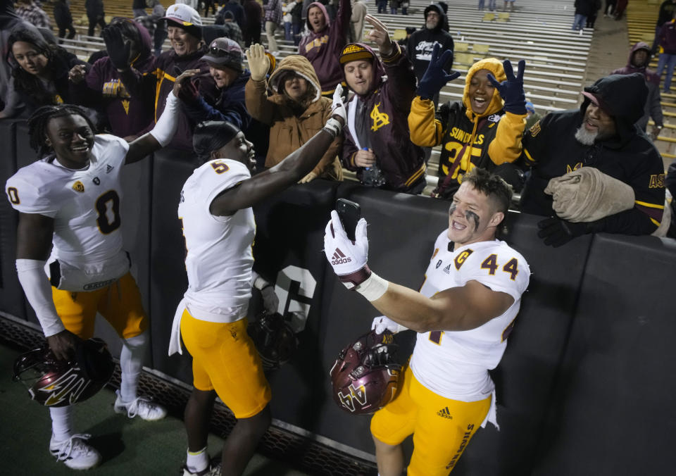 From left, Arizona State wide receiver Charles Hall IV, defensive back Chris Edmonds and fullback Case Hatch celebrate with fans after an NCAA college football game against Colorado, Saturday, Oct. 29, 2022, in Boulder, Colo. (AP Photo/David Zalubowski)