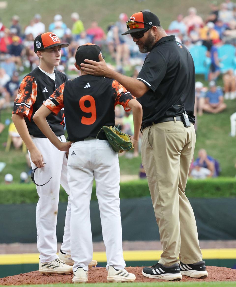 Smithfield manager Eric Gibree makes a mound visit to speak with his son, pitcher Gavin Gibree, during Friday's game vs. Nolensville, Tenn.