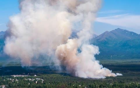 A brush fire burns in South Anchorage, Alaska - Credit: Loren Holmes/Anchorage Daily News via AP