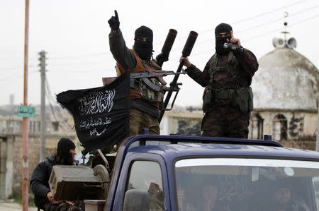 Members of al Qaeda's Nusra Front gesture as they drive in a convoy touring villages, which they said they have seized control of from Syrian rebel factions, in the southern countryside of Idlib, December 2, 2014. REUTERS/Khalil Ashawi