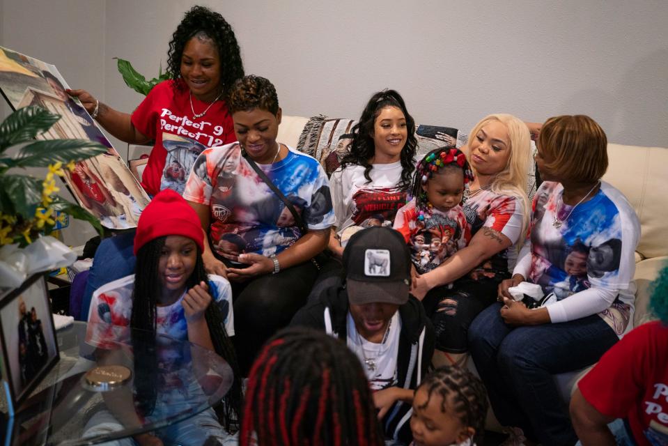 Crystal Cooper, second right, is surrounded by family members at her home in Swartz Creek, Thursday, Jan. 12, 2023. Cooper's two sons, Zy'Aire Mitchell, 12, and LaMar Mitchell, 9, died in a house fire last May after being trapped in a bedroom for more than six minutes following an all-clear issued by two Flint firefighters.