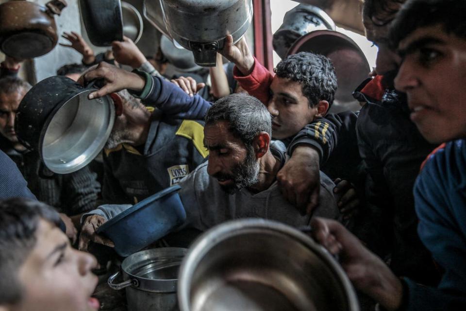 Palestinians react as they gather to collect aid food in Beit Lahia, in the northern Gaza Strip, on Feb. 26, 2024, amid continuing battles between Israel and the Palestinian militant group Hamas.